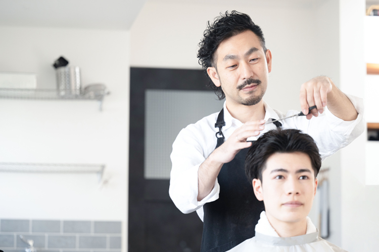 髪の毛をカットする美容師さん