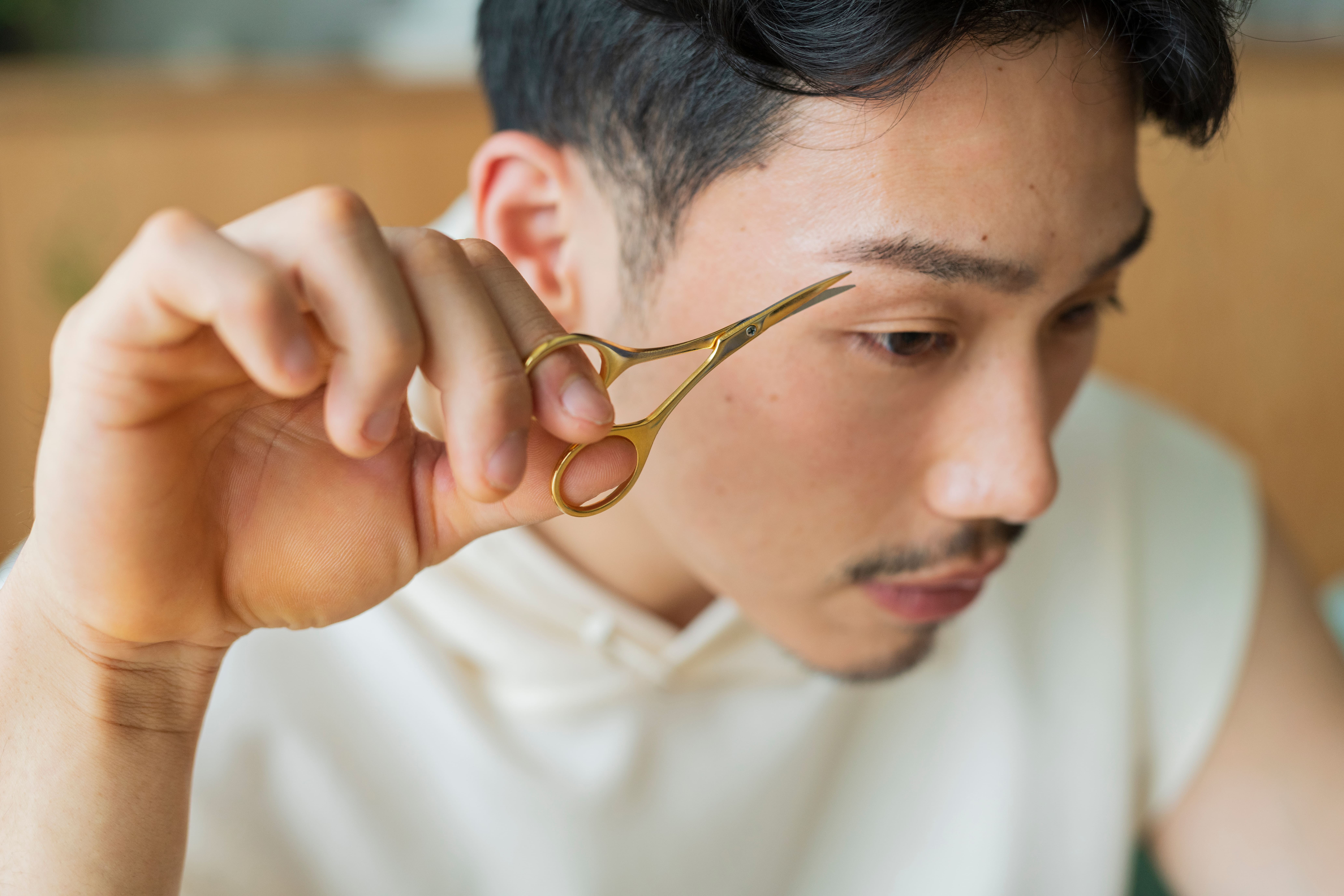 ハサミで眉毛を整える男性