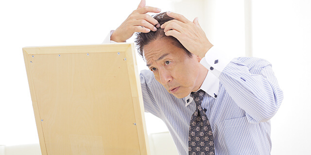 薄毛の悩みに頭を抱える男性